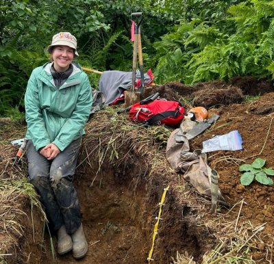 Elizabeth Eroshenko digging in a large hole in the soil