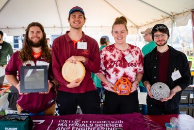 students stand at table during alumni weekend tailgate