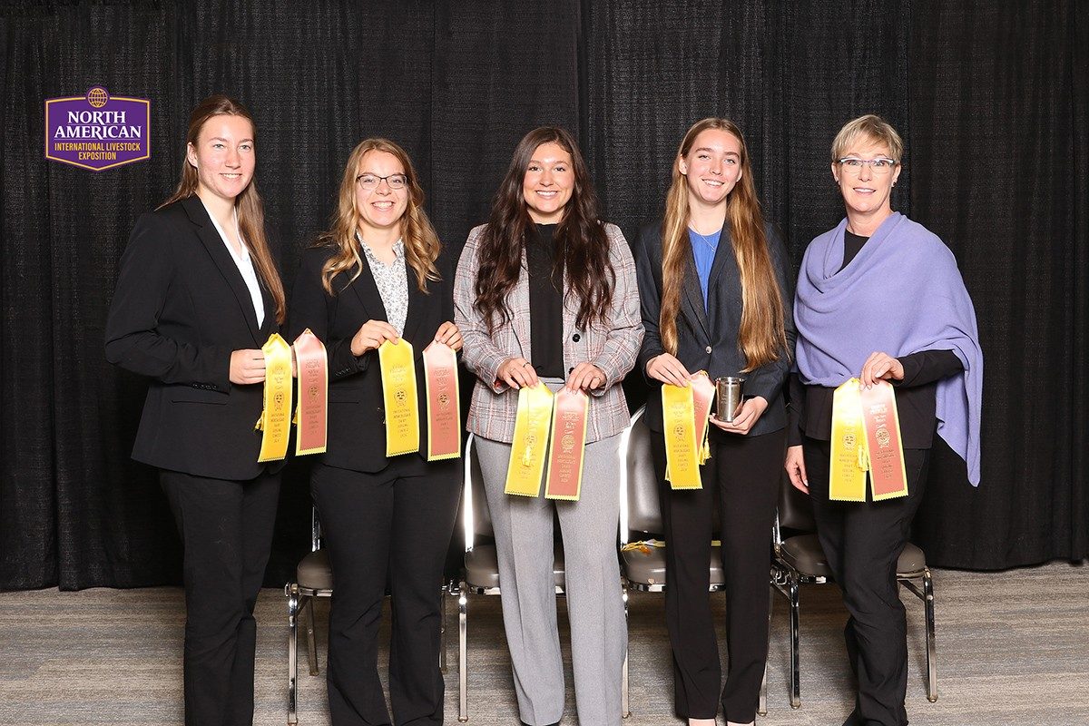 Four team members and their coach holding ribbons in Louisville.