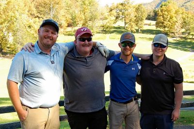 Team Birdie Bovines standing together with their arms over their team mates shoulders smiling on the golf course.