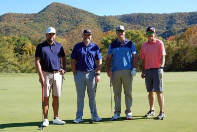 Team Farm Credit Green, standing together, with their golf clubs and facing the camera on the golf course.