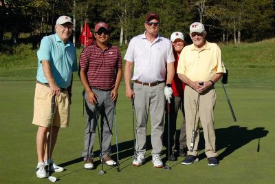 Team Joe Lineweaver and Friends, standing together, with their golf clubs and facing the camera on the golf course.