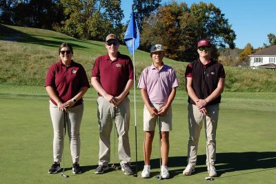 Team Southland Dairy Farmers standing together with their golf clubs by the flagstick on the green.