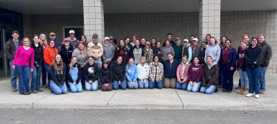 A large group of Virginia Tech Animal and Poultry Sciences students and faculty pose outside a campus building after competing in the 2025 Academic Quadrathlon.