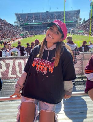 Cassie Borino at a Virginia Tech football game. She is standing in the north endzone stands with the field in the background.