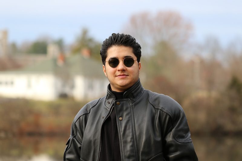 Young man in sunglasses and jacket. Blurred background.