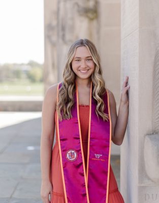 Young woman wearing a dress and Virginia Tech graduation stole at VT War Memorial.