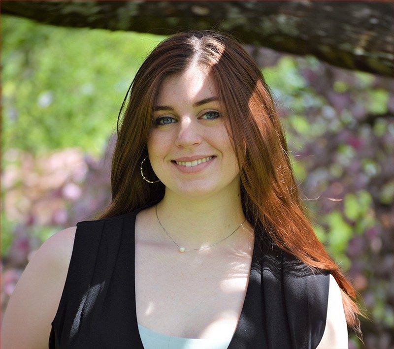 Photo of Hailey Galyon with foliage in the background.