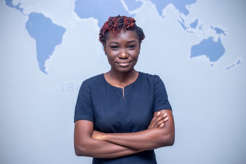 Graduate student, Naa Adei Kotey. Blue world map in the background.