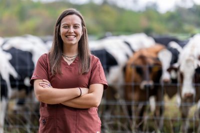 Kelly Gillespie posing in front of a cow field