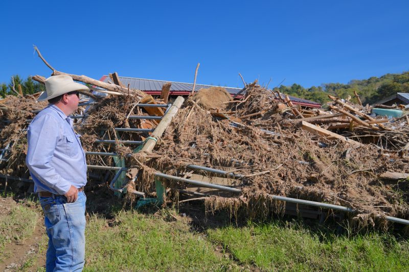 A man looks at a giant pile of debris