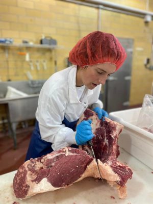 Student worker cutting beef in the Virginia Tech Meat Center.