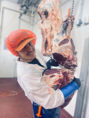 Student worker cutting beef in the Virginia Tech Meat Center.