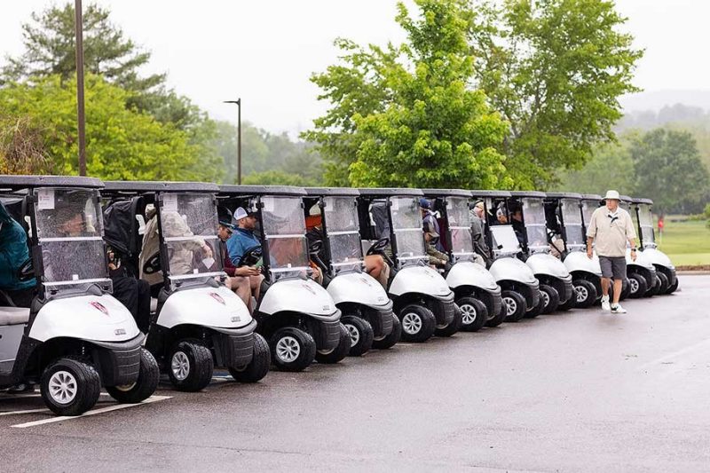 Golf carts lined up, ready to go in the rain. 2023.