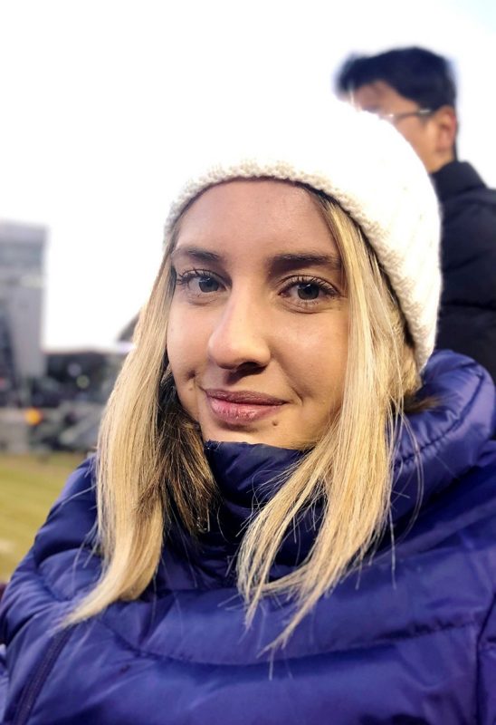 Photo of Sabrina Amorim at a cold VT football game wearing a parka and toboggan.